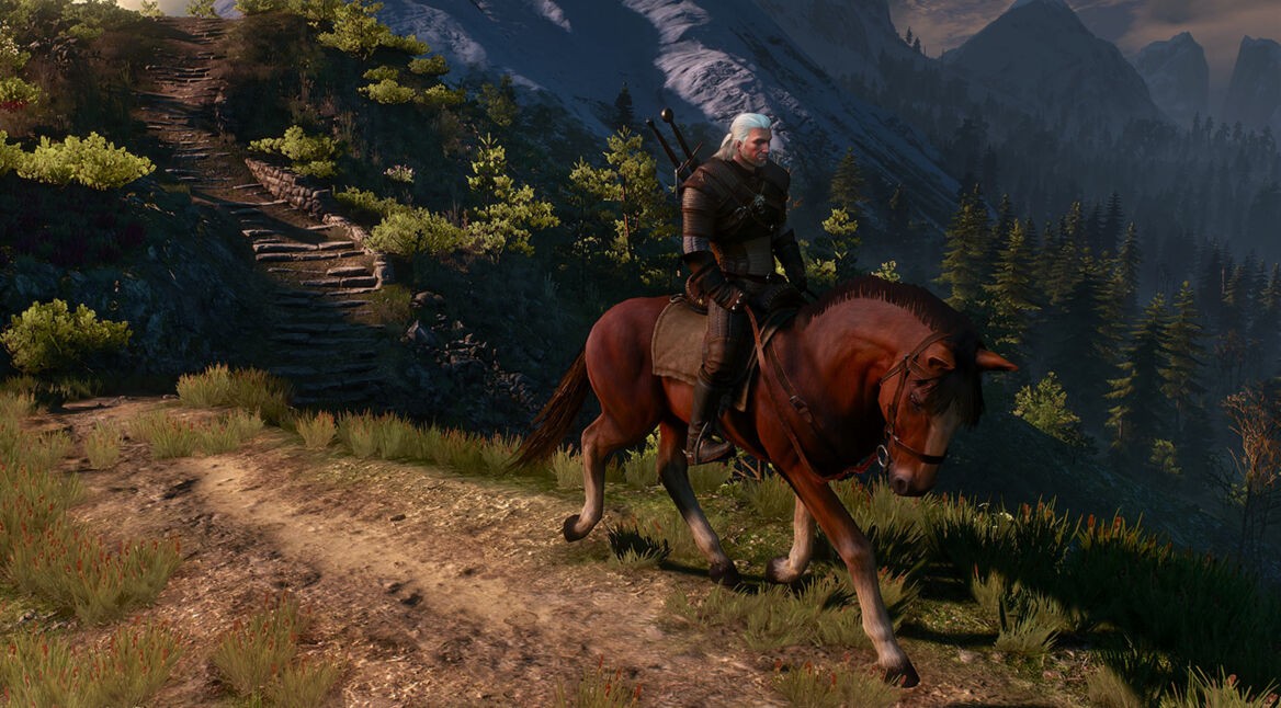 Auf dem Bild aus The Witcher 3 ist Geralt von Riva auf seinem Pferd Plötze zu sehen, wie er einen Waldweg entlangreitet. Die Szene ist atmosphärisch mit Bergen und Sonnenuntergang im Hintergrund. Das Bild steht beispielhaft für visuelle Easter Eggs in Games, die sich in der liebevollen Gestaltung der Spielwelt widerspiegeln.