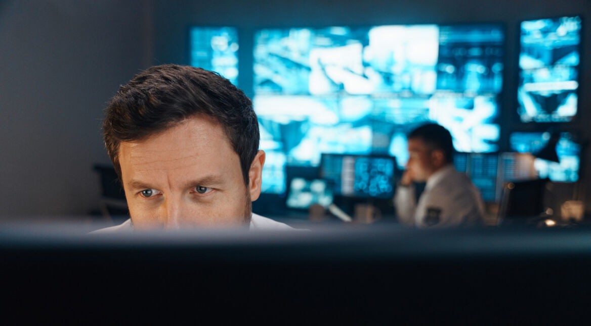 Polizist schaut auf Bildschirm