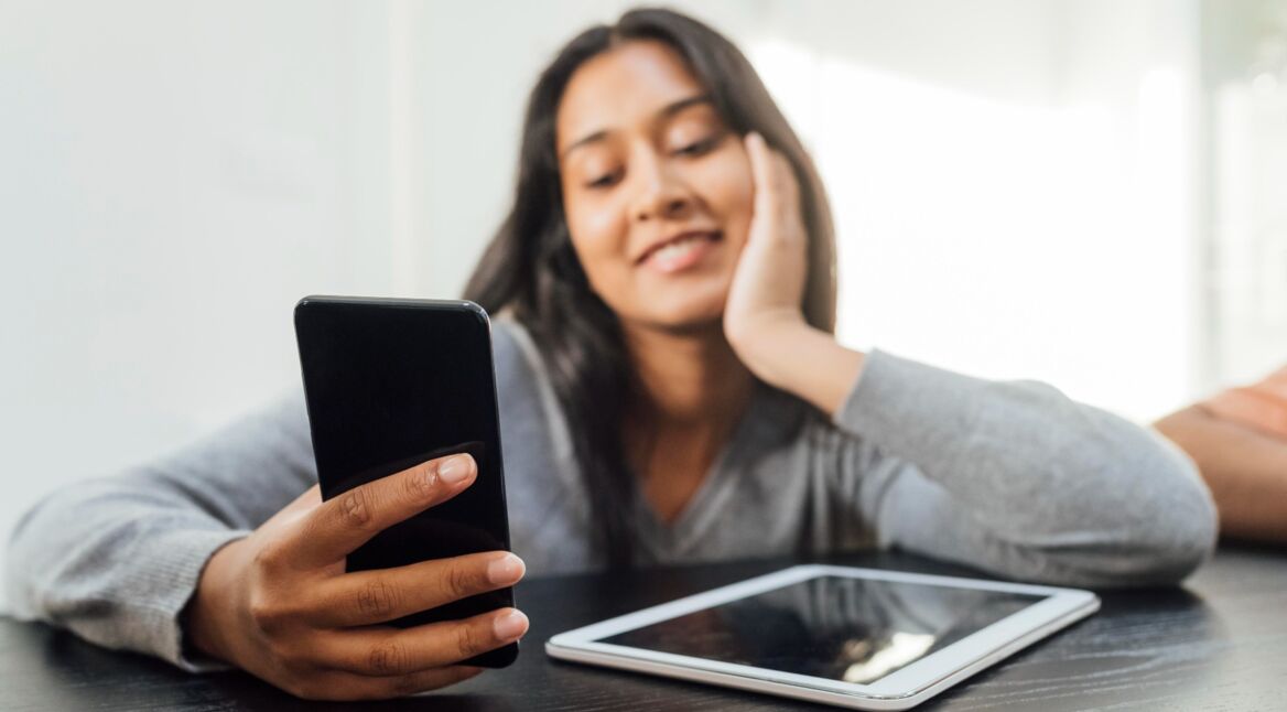 Junge Frau mit Smartphone und Tablet