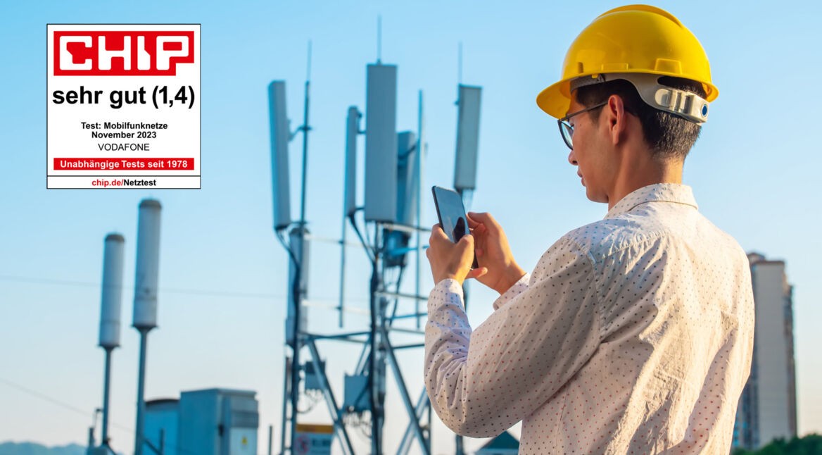 Ein Mann steht mit einem Smartphone und einem Bauarbeiterhelm vor einem Funkmast und prüft seine Verbindung. Ein Chip-Testsiegel ist im linken Bildbereich zu sehen mit der Gesamtnote "sehr gut"