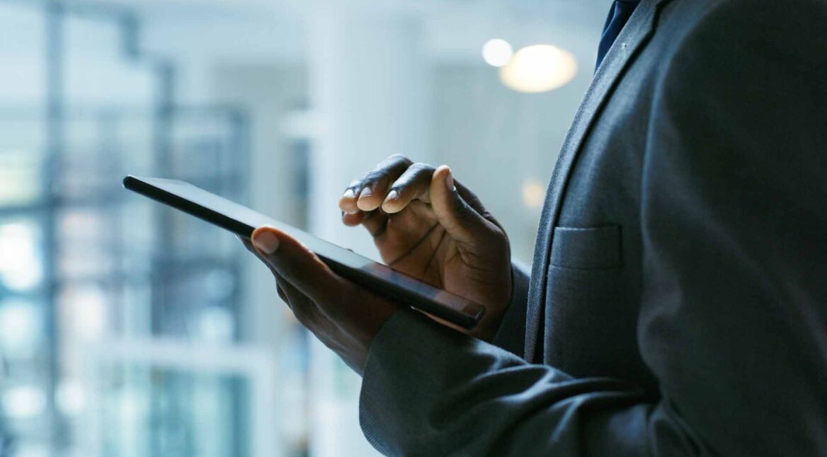 Hände eines Geschäftsmannes auf einem iPad