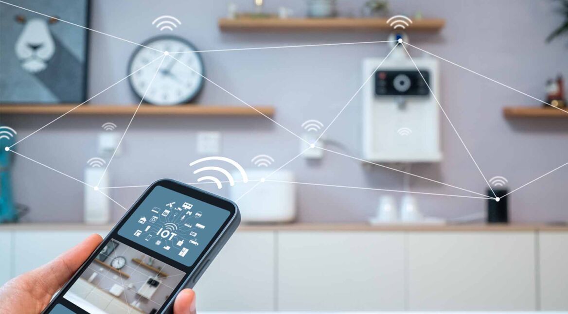 Ein Smartphone in der Hand steuert Geräte im Smart Home an