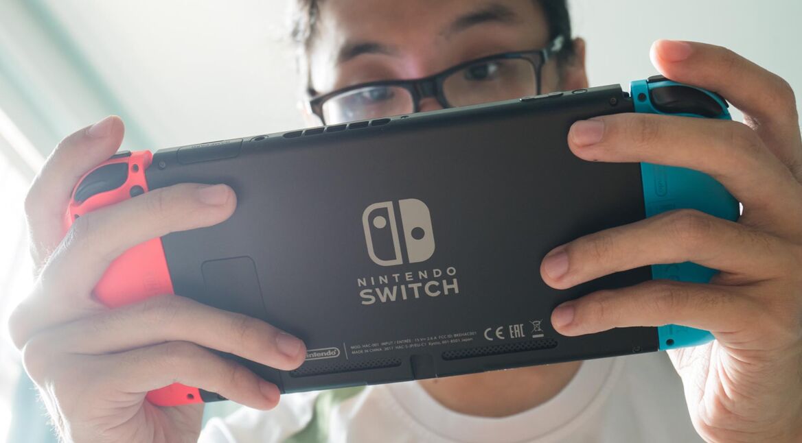 Ein Mann hält eine Nintendo Switch in der Hand