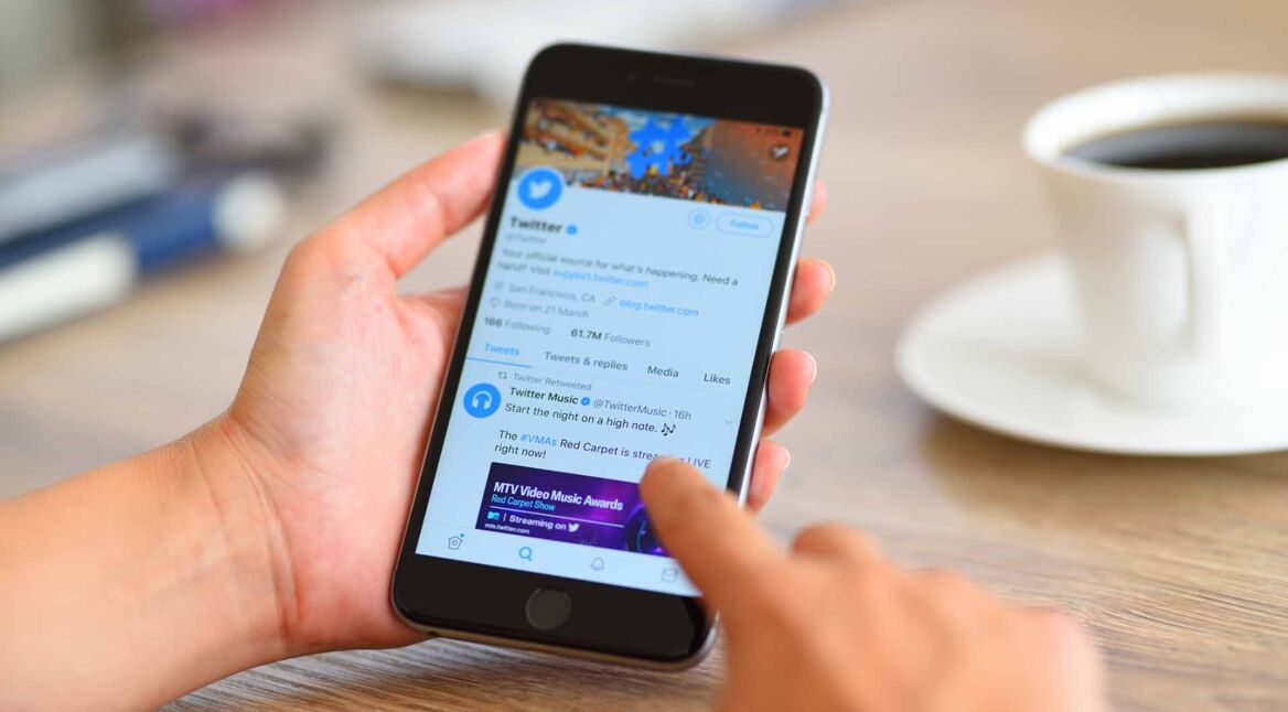 Ein Smartphone in einer Hand mit geöffneter Twitter-App