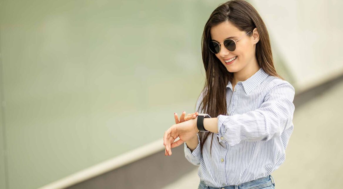 Frau überprüft die Zeit auf ihrer Smartwatch