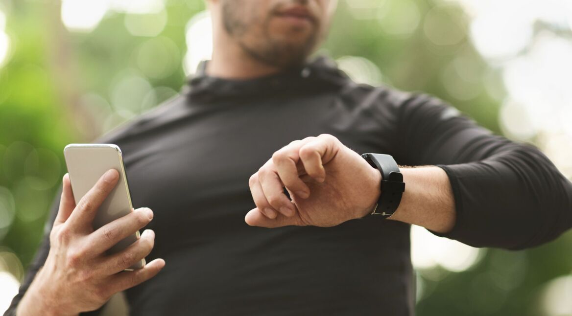 Mann schaut auf die Smartwatch am Arm.