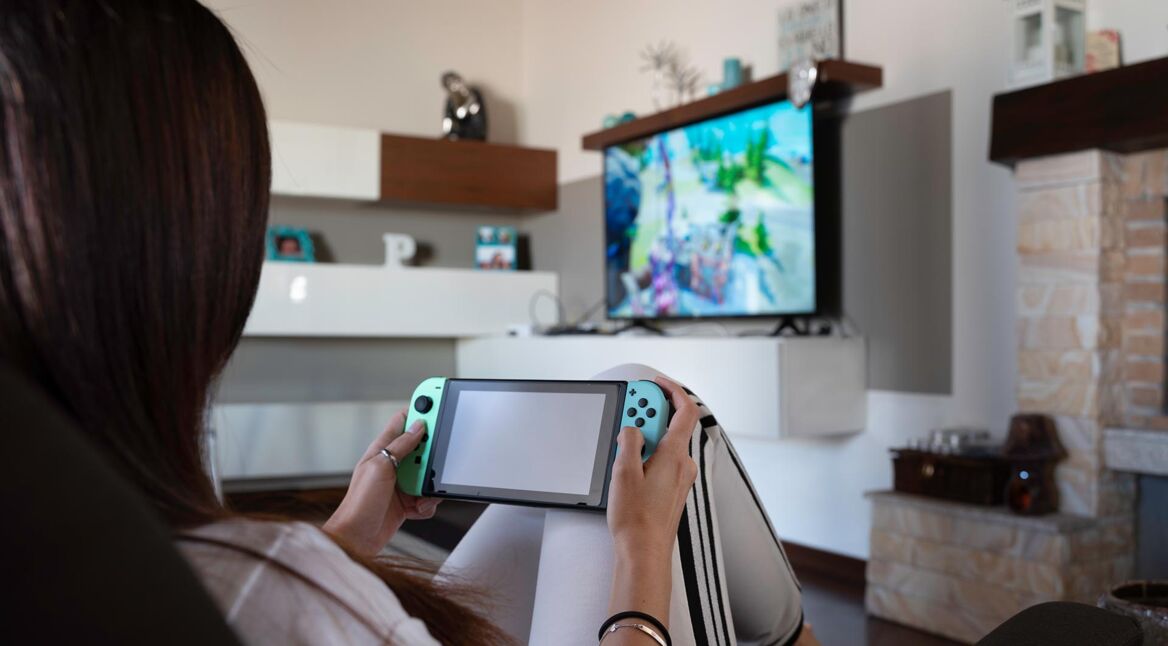 Eine junge Erwachsene zockt Spiele auf der Nintendo Switch