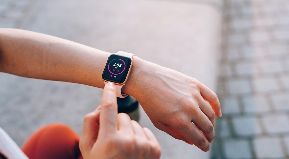 Jemand tippt auf seine Smartwatch am Arm beim Training