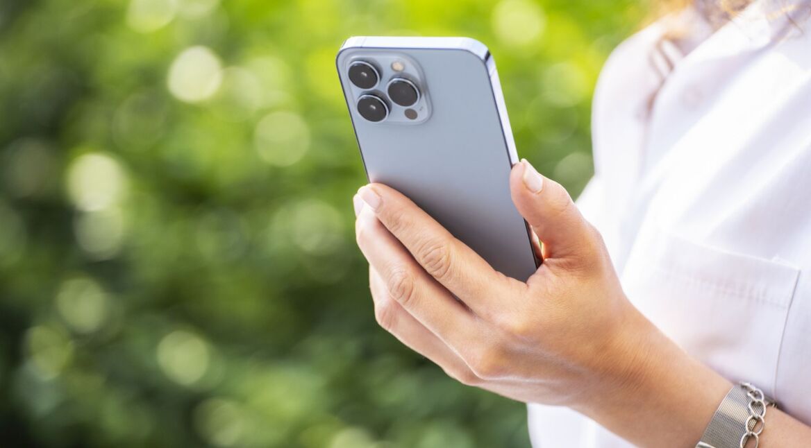 Frau schaut sich ein Kontaktposter auf dem iPhone an.