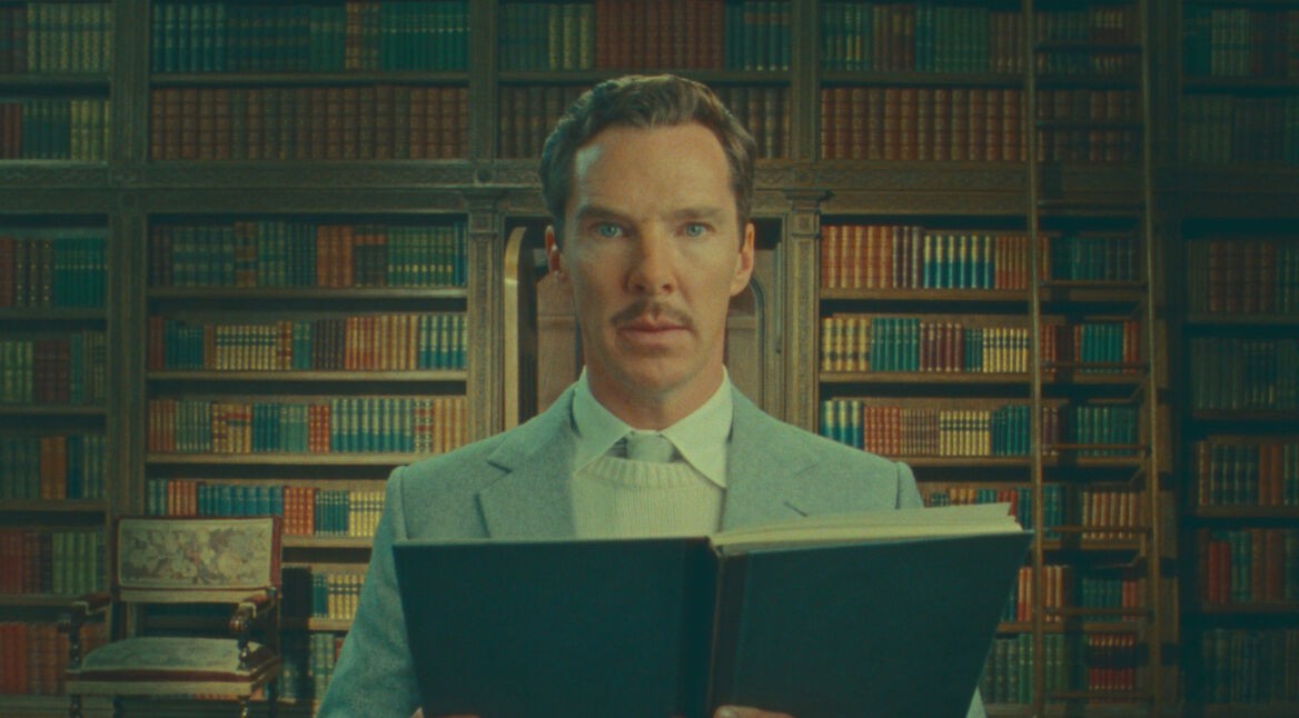 Benedict Cumberbatch schaut mit einem Buch in der Hand in die Kamera