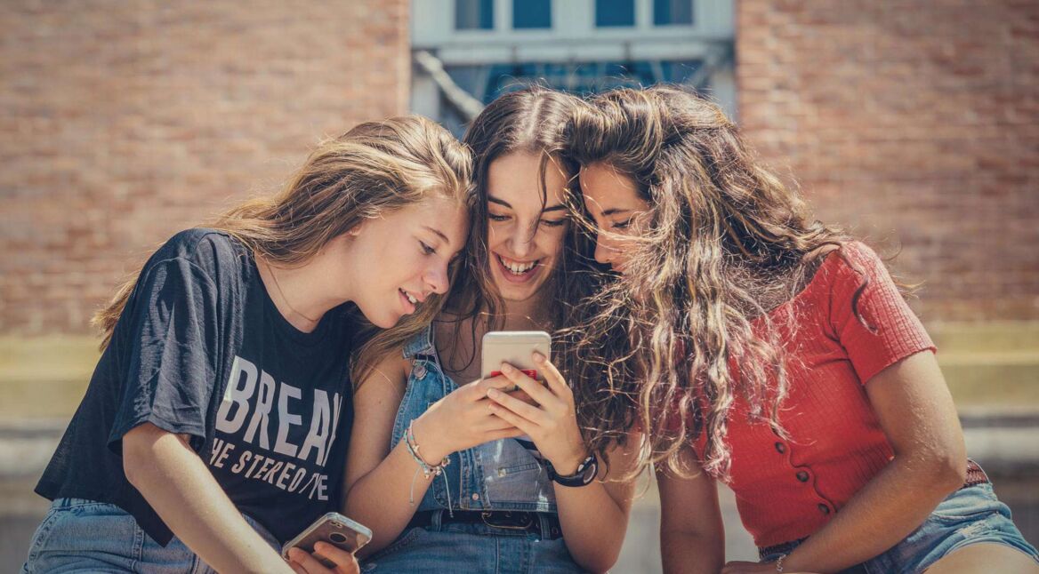 Mädchen schauen sich gemeinsam TechHacks auf dem Handy an