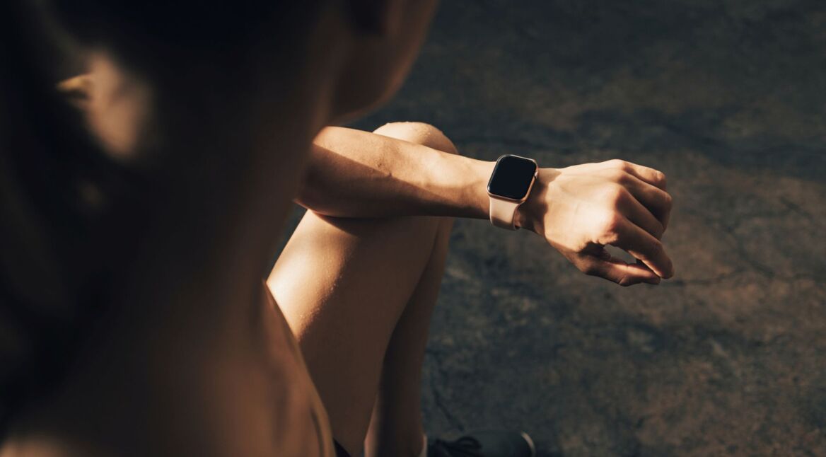 Frau schaut auf ihre Apple Watch am Handgelenk