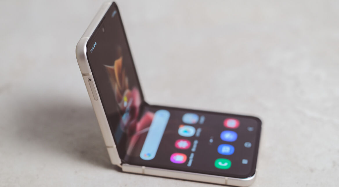 Das Smartphone Samsung Galaxy Z Flip liegt aufgeklappt auf einer marmorierten Fläche