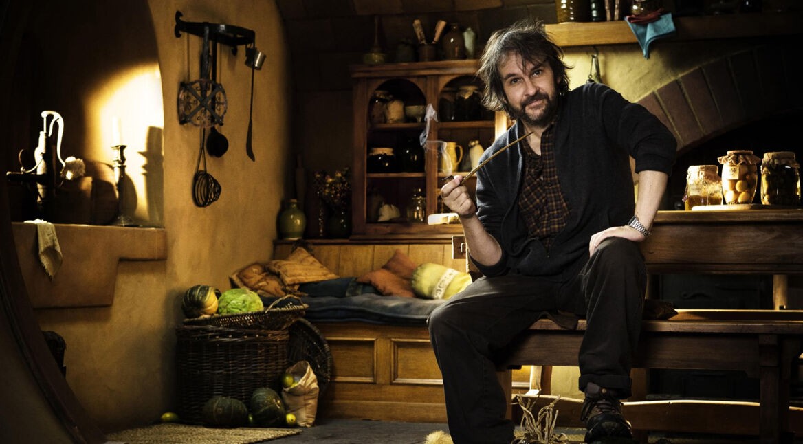 Peter Jackson sitzt auf einer Holzbank an seinem Set von Der Hobbit