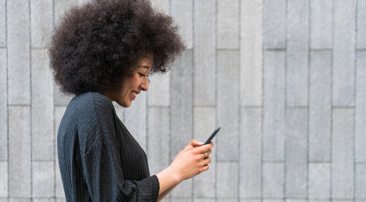 Eine junge Frau schaut auf ihr Smartphone