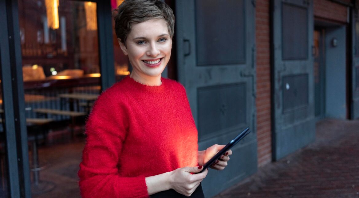 Eine junge Frau mit einem Tablet in den Händen.
