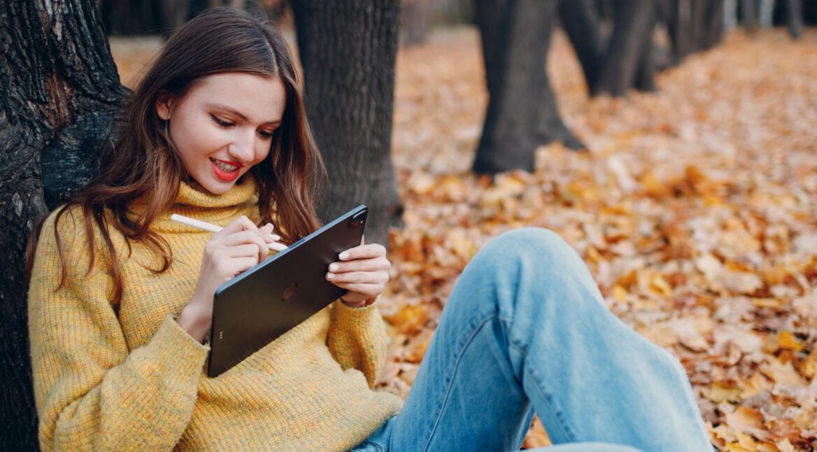 Frau schreibt mit Apple Pencil auf dem iPad Pro.