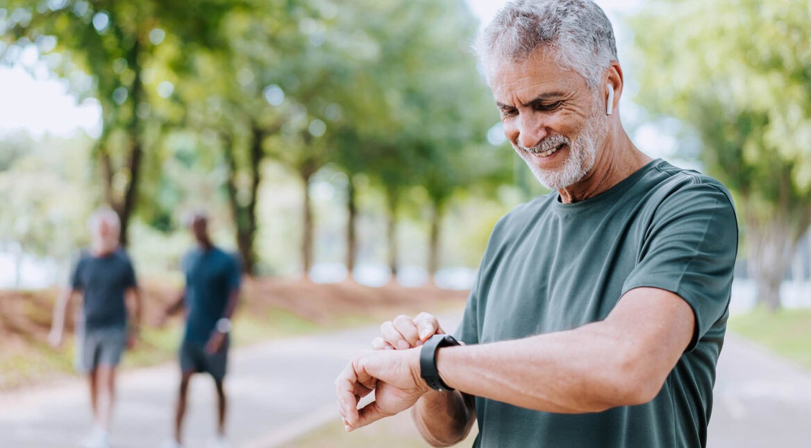 Ein älterer Herr schaut auf seine Smartwatch