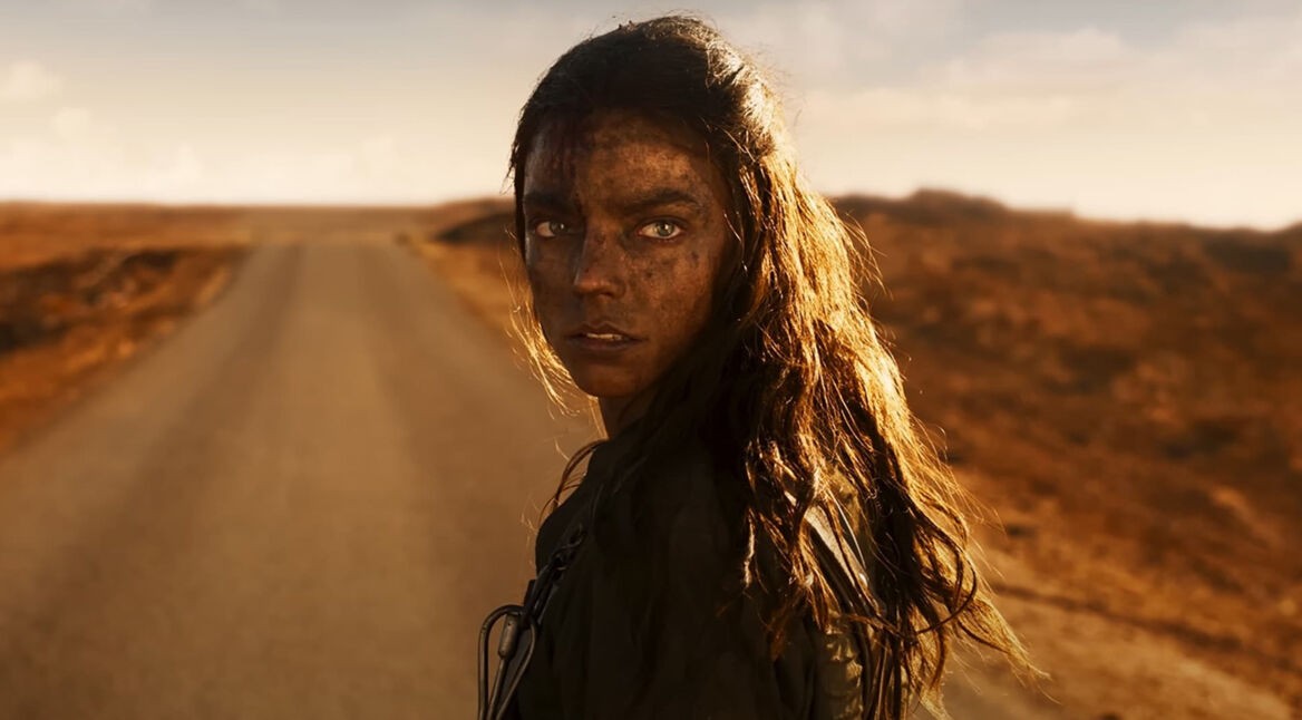 Das Bild im Artikel zu den GigaTV-Highlights im Juli 2024 zeigt Anya Taylor-Joy als Furiosa im Film Furiosa: A Mad Max Saga mit schmutzigem Gesicht und langem, dunklem Haar, die auf einer einsamen, staubigen Straße in einer kargen Wüstenlandschaft steht. Sie schaut ernst und direkt in die Kamera. Im Hintergrund ist der Himmel teils bewölkt.