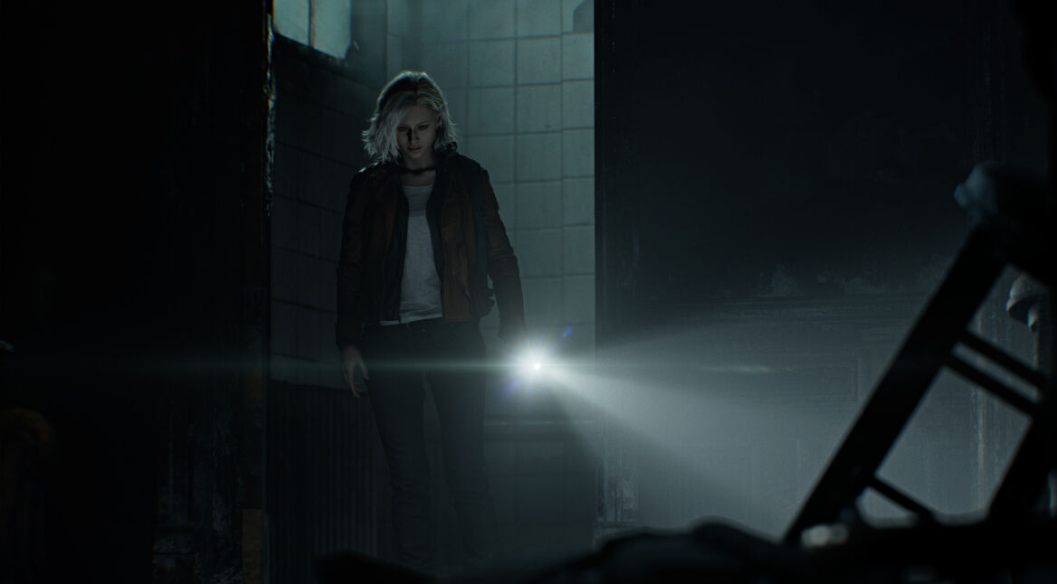In dieser Szene aus Resident Evil Requiem betritt Protagonistin Grace Ashcroft einen düsteren, verfallenen Raum. Mit ernster Miene leuchtet sie mit einer Taschenlampe in die Dunkelheit. Die Umgebung wirkt verlassen und bedrohlich – schmutzige Kacheln, kaputte Möbel und schwaches Licht unterstreichen die unheimliche Atmosphäre von Resident Evil 9