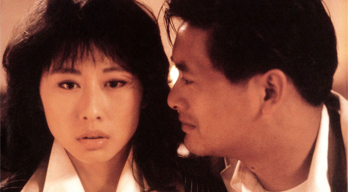 In "The Killer" von 1989 sitzen der Auftragskiller und die Sängerin Jennie nebeneinander, er schaut sie dabei an.