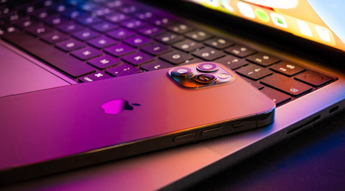 MacBook pro 2021 halb geöffnet, ein iPhone 13 liegt darauf