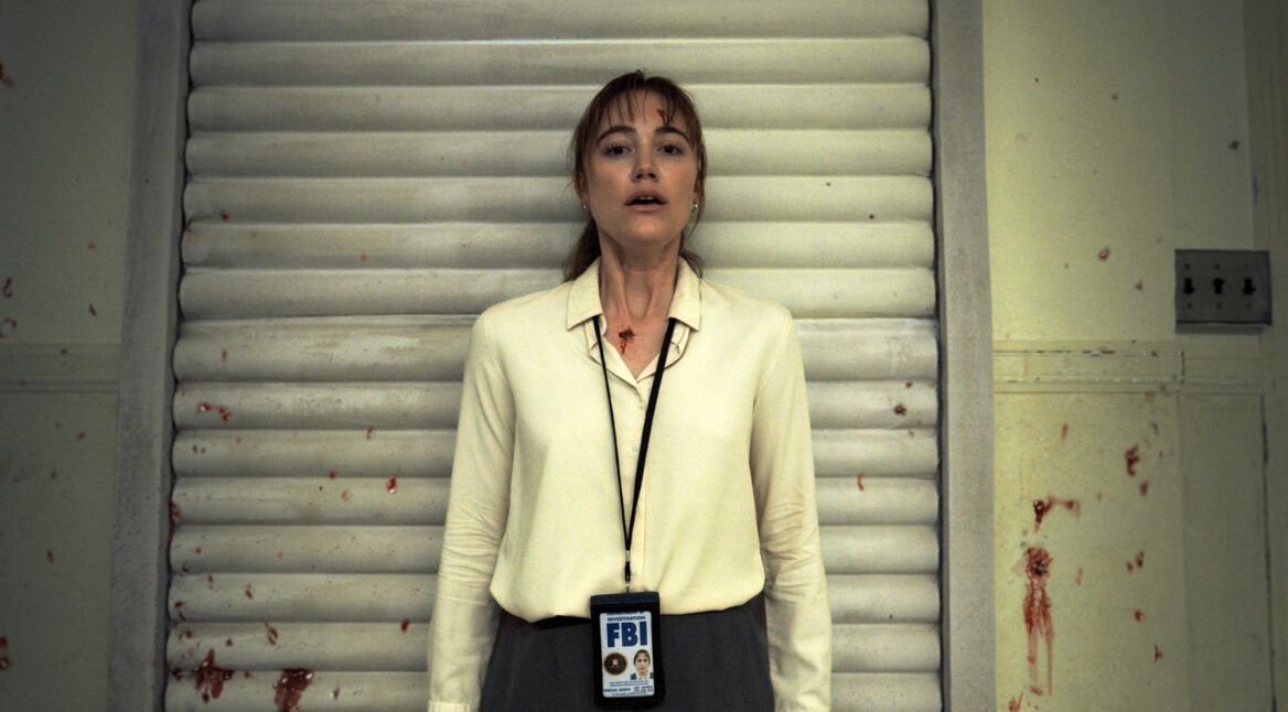 Eine Frau vor einer blutbespritzten Wand.