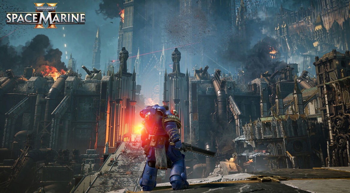 Auf dem Bild aus Warhammer 40.000: Space Marines 2 steht ein einzelner Space Marine in blauer Rüstung mit einer Kettensägewaffe vor einer gewaltigen, gotischen Festung. Flammen und Rauch steigen aus der Festung empor, während Laserstrahlen den Himmel durchschneiden. Die Architektur ist imposant und düster, mit Türmen und riesigen Rohren. Der Space Marine blickt in Richtung des Schlachtfelds, bereit für den Kampf. Das Bild unterstreicht die epische und düstere Stimmung des Spiels.