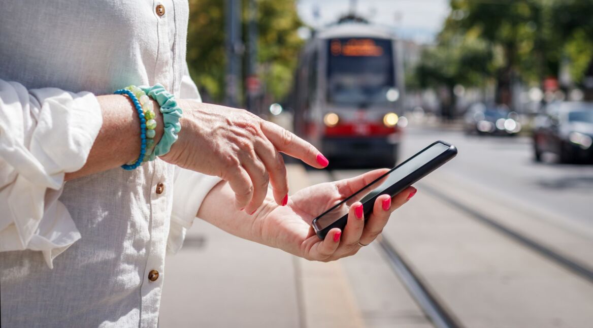 Frau mit lackierten Nägel tippt auf ihrem Smartphone