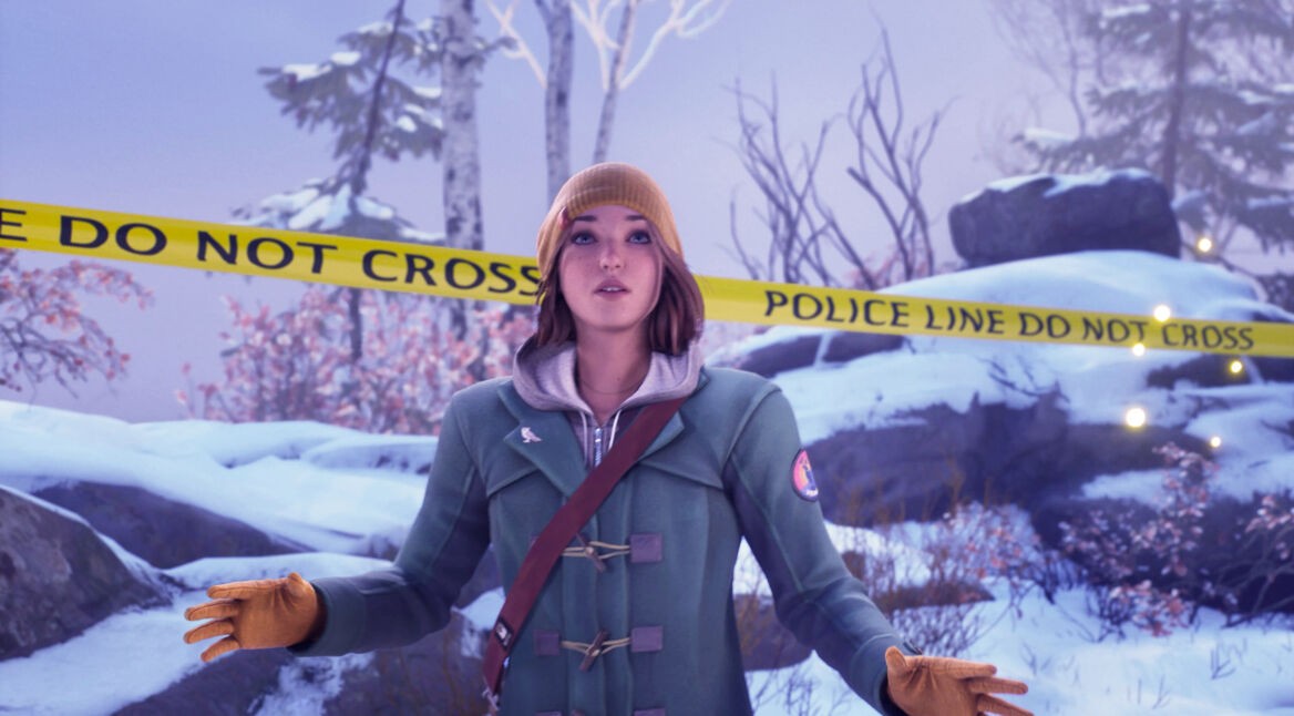 Auf dem Bild aus Life is Strange: Double Exposure Test ist Max vor einem mit gelbem „Police Line Do Not Cross“-Absperrband in einer verschneiten Waldlandschaft zu sehen. Sie trägt eine gelbe Mütze, einen grünen Mantel und braune Handschuhe. Ihr Gesichtsausdruck wirkt nachdenklich und konzentriert, als ob sie an einem Tatort Hinweise untersucht. Die winterliche Umgebung verstärkt die kühle, mysteriöse Stimmung der Szene.