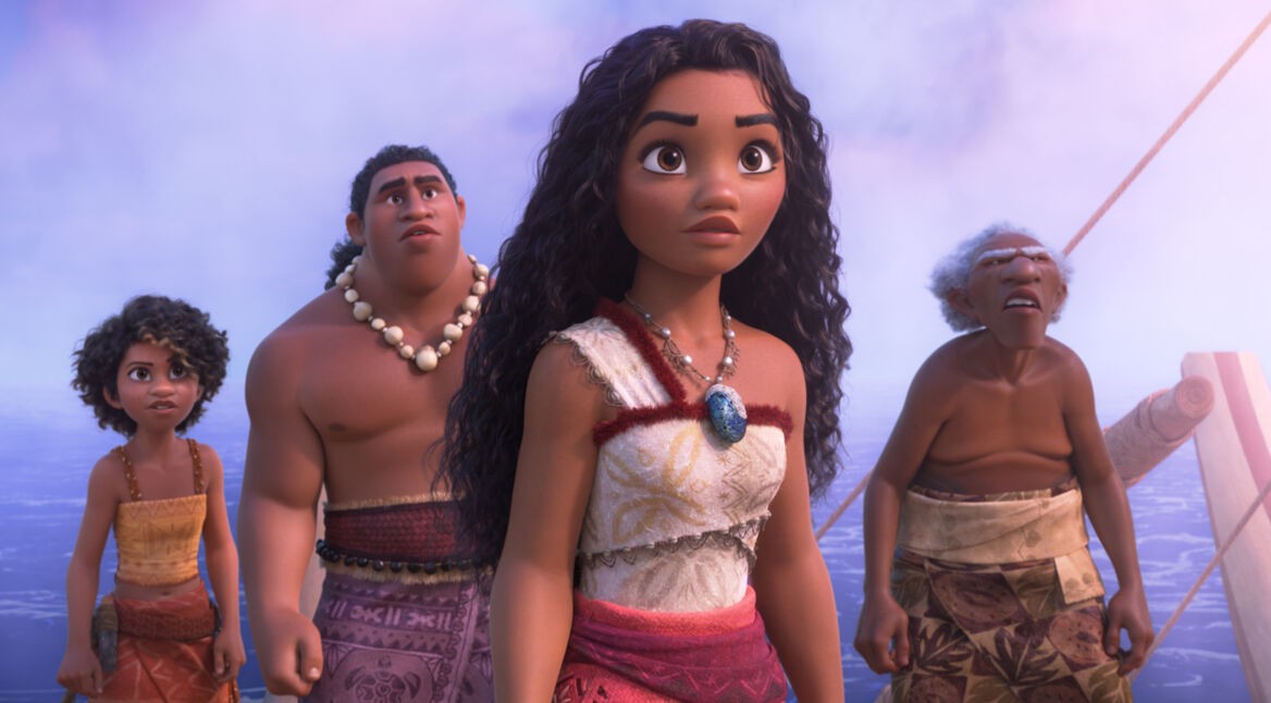 Auf diesem Bild aus Vaiana 2 steht Vaiana mit entschlossenem Blick in der Mitte, umgeben von drei anderen Charakteren aus ihrem Dorf. Links von ihr steht ein jüngeres Mädchen, rechts ein kräftiger Mann mit einer Halskette aus Muscheln, und ganz rechts ein älterer Mann mit grauem Haar. Sie befinden sich auf einem Boot, das auf dem Ozean segelt, während der Himmel in Pastelltönen leuchtet.