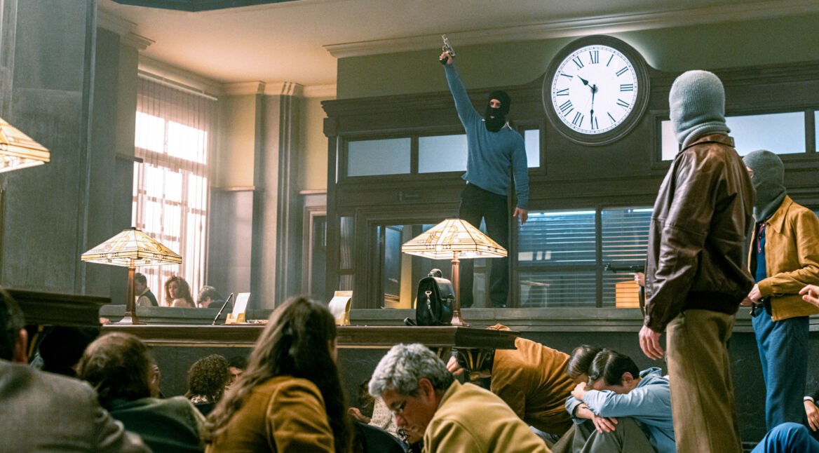 Maskierter, bewaffneter Bankräuber schüchtert Geiseln ein.