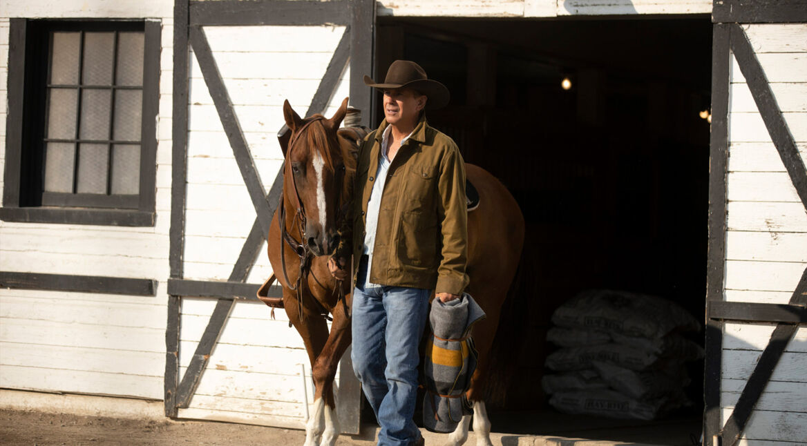 Auf dem Bild in dem Artikel über die Yellowstone Reihenfolge, ist zu sehen, wie ein Mann mit einem Pferd aus einem Stall läuft.