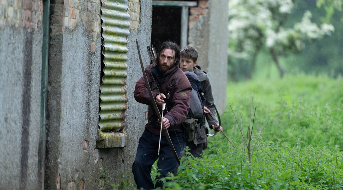 Auf dem Bild aus 28 Years Later sind Jamie, gespielt von Aaron Taylor-Johnson, und sein Sohn Spike, dargestellt von Alfie Williams, zu sehen.