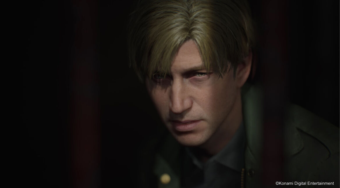 Auf dem Bild aus dem Silent Hill 2 Remake ist James Sunderland zu sehen, ein Mann mit blonden Haaren und ernstem Ausdruck. Sein Gesicht ist detailliert und von düsterem Licht umgeben, was die melancholische und unheimliche Stimmung des Spiels unterstreicht. Das Remake gilt als eines der beste Games 2024.