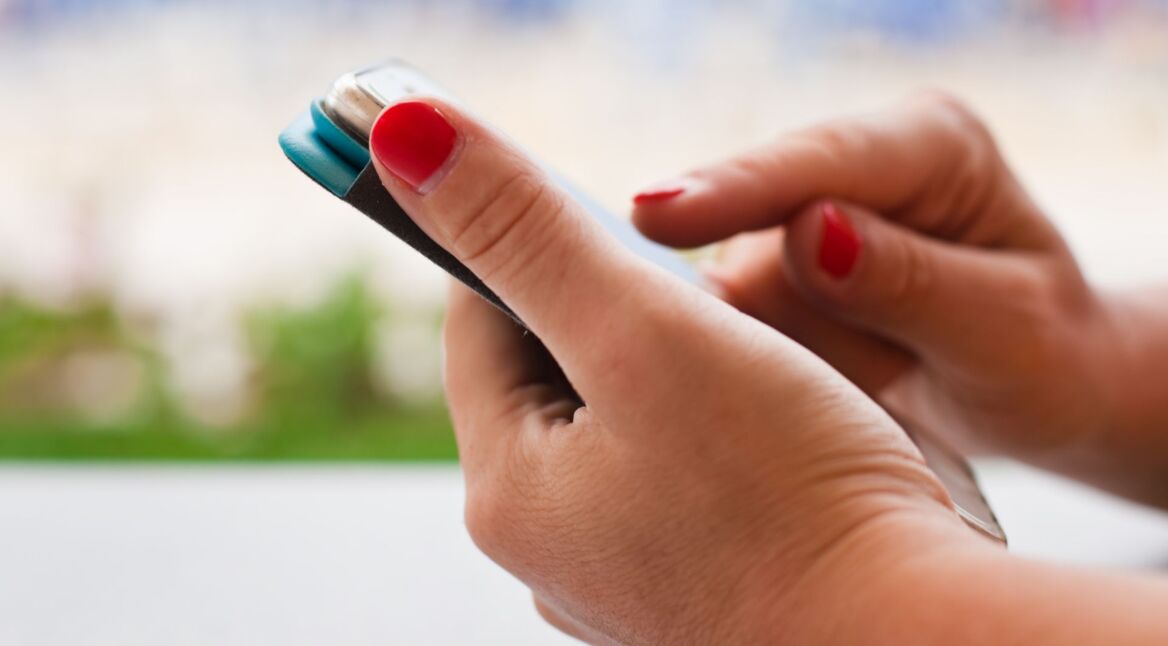 Frau tippt auf das Display ihres Smartphones.