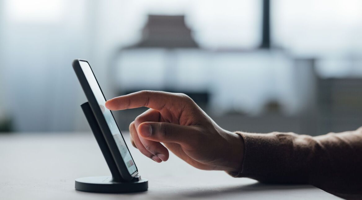 Mann tippt mit seinem Finger auf das Display eines Smartphones