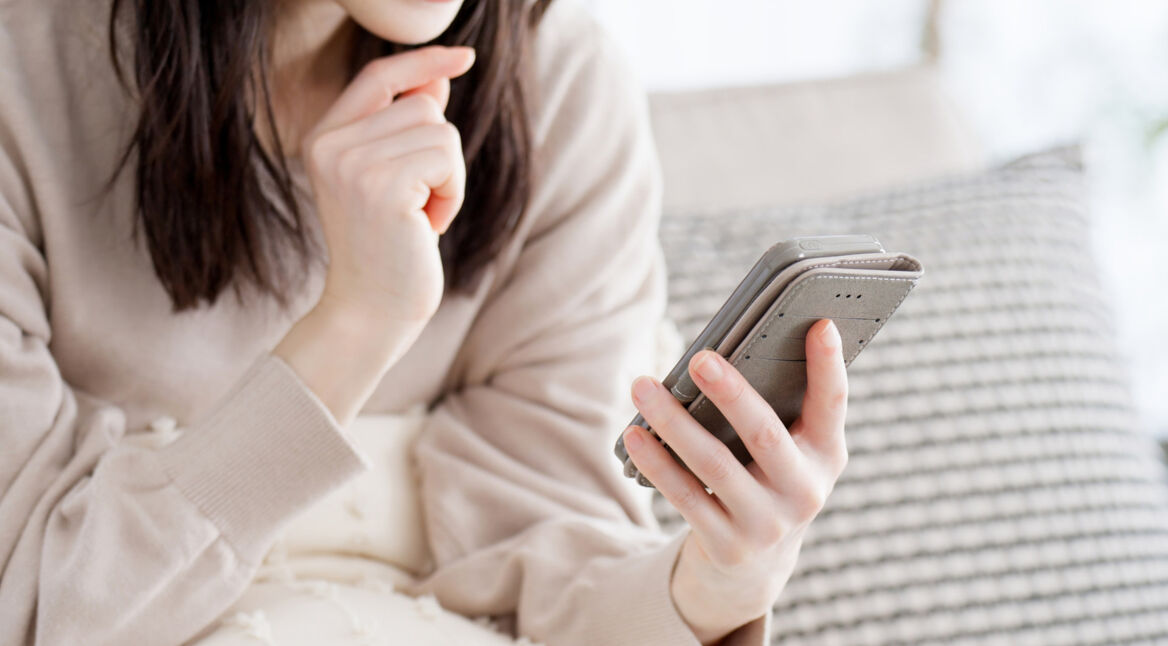 Eine Person hält ein Smartphone in der Hand und schaut auf den Bildschirm.