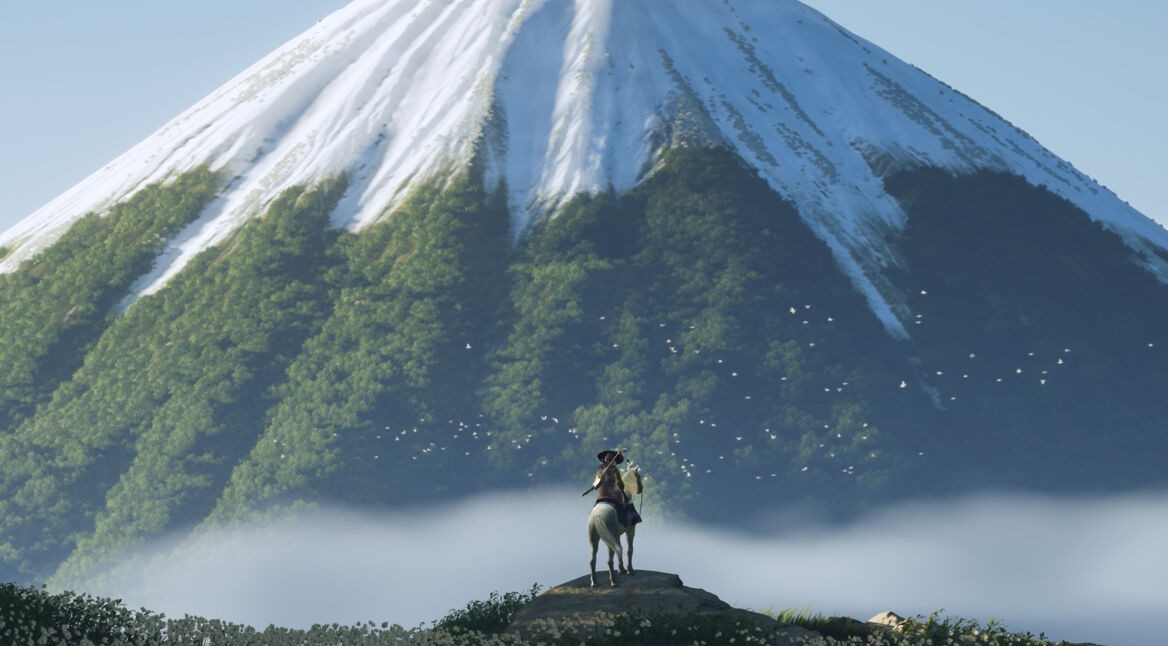 Im Bild aus dem Videospiel Ghost of Yotei steht ein:e Reiter:in mit Hut auf einem Felsen, während sein:ihr Pferd ruhig verweilt. Im Hintergrund erhebt sich ein majestätischer Berg, dessen grüne Wälder von einer Schneeschicht bedeckt sind. Um den Berg fliegen weiße Vögel, die eine friedliche Stimmung unterstreichen. Nebel bedeckt das Tal.