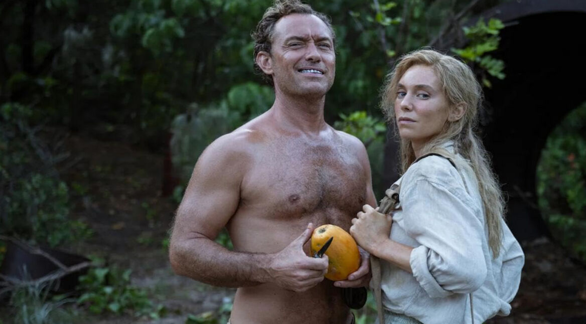 Jude Law als Philosoph Dr. Friedrich Ritter und seine Frau Dore Strauch stehen im Dschungel, während er eine Frucht in der Hand hält.