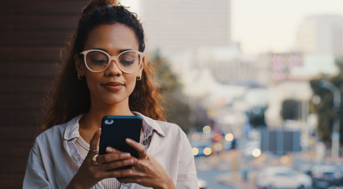 Eine junge Frau hält ein Smartphone in der Hand