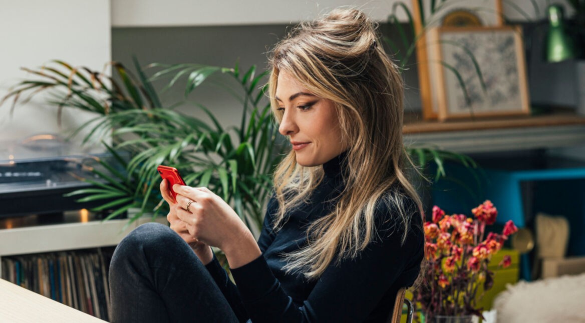 Eine junge Frau schaut auf ihre Smartphone.