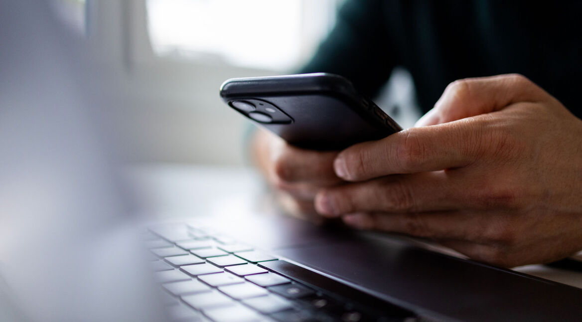 Eine Person hält ein Smartphone in der Hand.