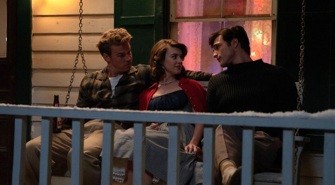 Im Bild zur On Swift Horses-Kritik sitzen Lee (Will Poulter), Muriel (Daisy Edgar-Jones) und Julius (Jacob Elordi) eng nebeneinander auf einer Veranda-Schaukel. Die Stimmung wirkt gespannt und emotional aufgeladen. Muriel sitzt zwischen den beiden Männern, schaut Julius direkt an, während Lee sie beschützend umfasst. Im Hintergrund leuchtet warmes Licht durch ein Fenster und verstärkt die intime Atmosphäre der Szene.