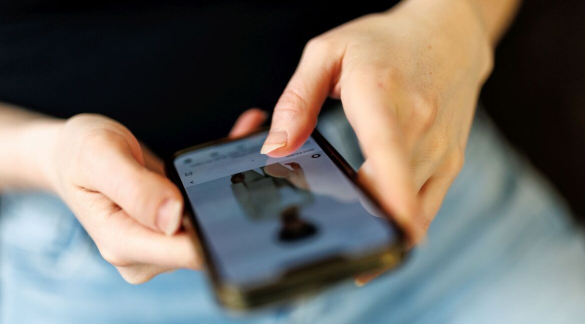 Eine junge Frau benutzt die Instagram-App auf ihrem Smartphone.