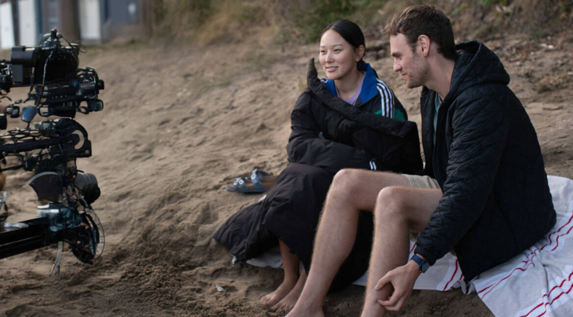 Eine Frau und ein Mann sitzen am Strand.