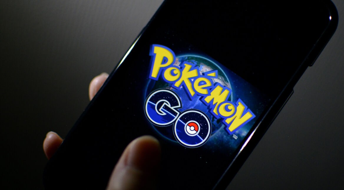 Eine Hand hält ein Smartphone, auf dem das "Pokémon GO"-Logo zu sehen ist.