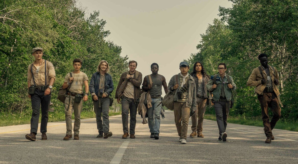 Mehrere junge Männer gehen in einer Reihe eine Straße entlang.