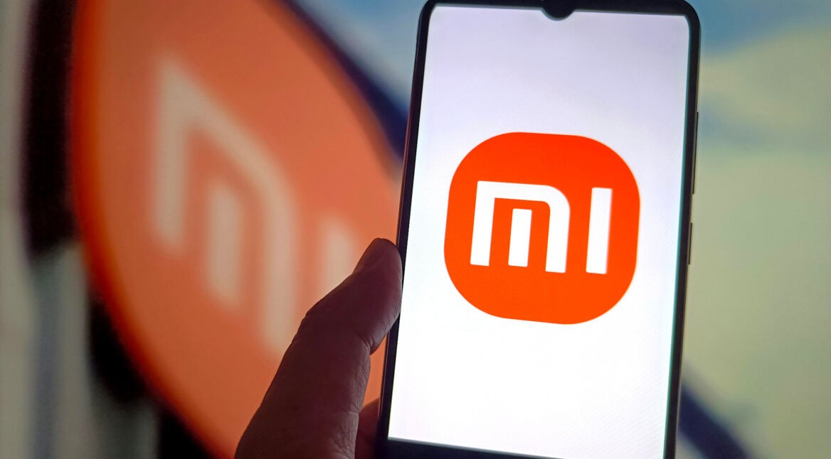 Hand hält ein Xiaomi-Smartphone mit dem Schriftzug "Mi" auf dem Display