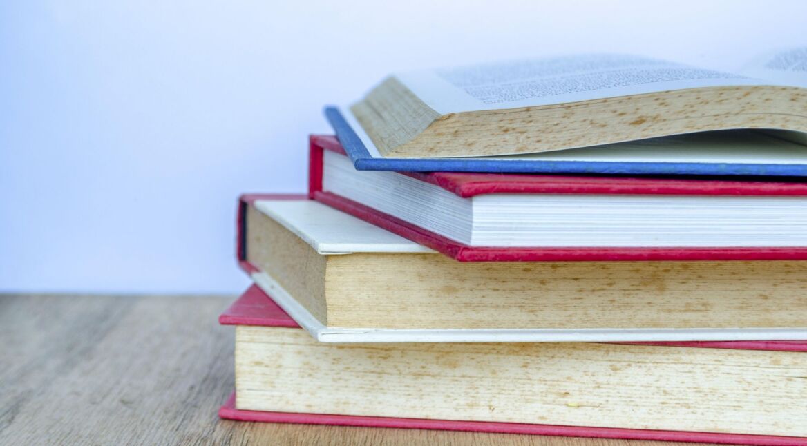 Die Nahaufnahme eines Bücherstapels auf einem Tisch.